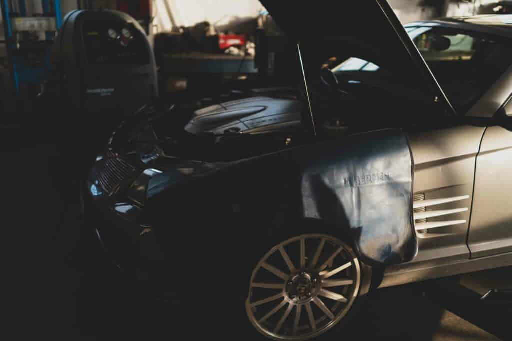 car in a mechanic shop with hood up