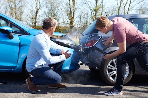 two people looking at a car wreck