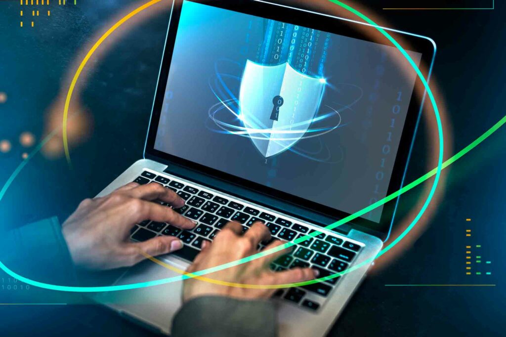 hands on a computer with a security symbol representing cyber liability insurance
