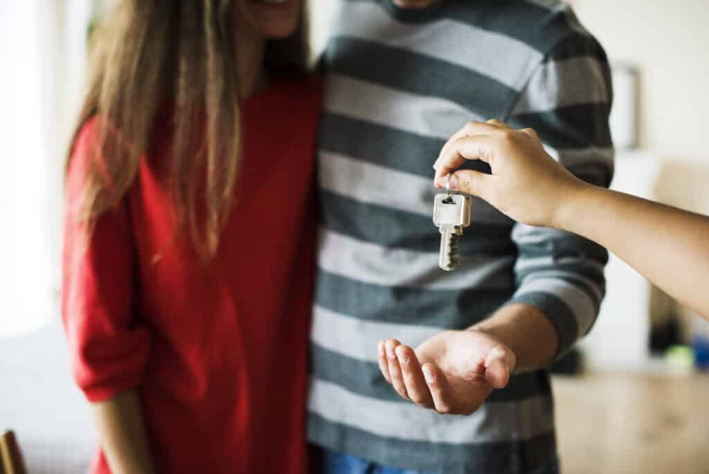 A landlord handing keys to the new tenants of a rental property