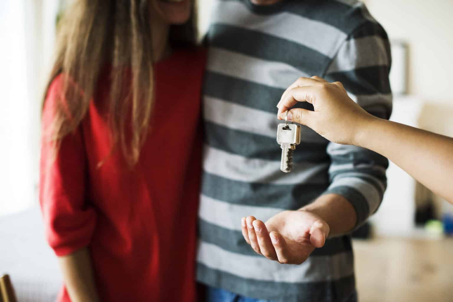 A landlord handing keys to the new tenants of a rental property