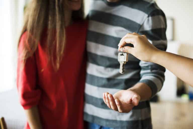 A landlord handing keys to the new tenants of a rental property