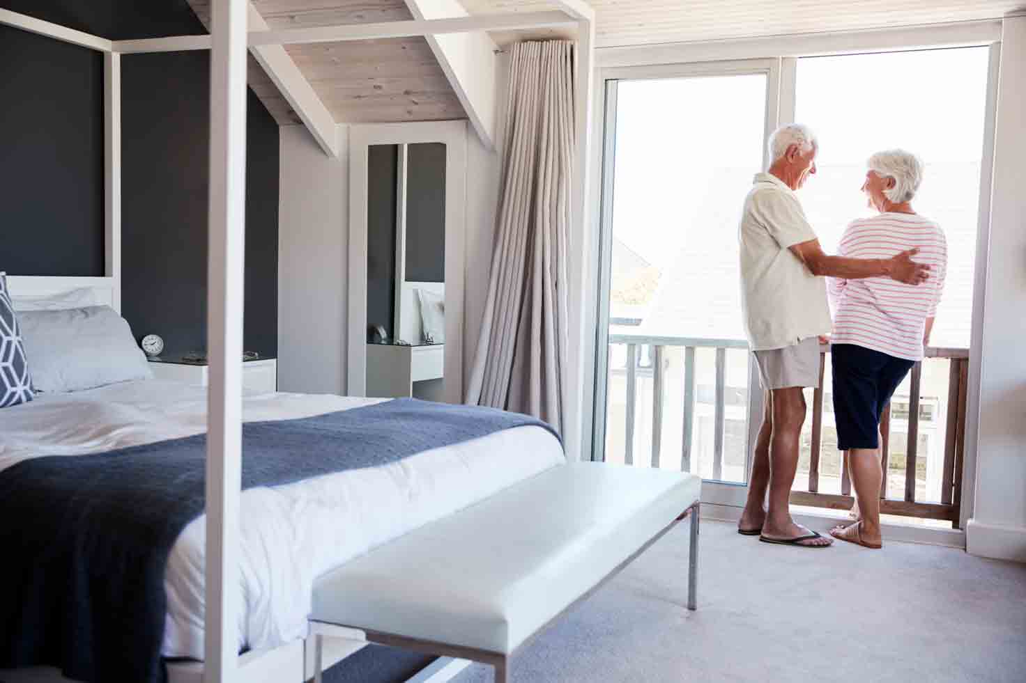 vacation rental property insurance concept with an elderly couple by the window of their short-term rental property