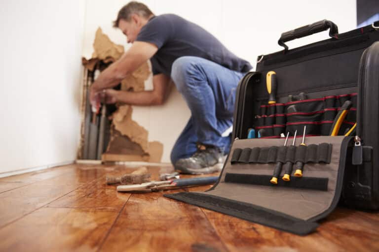 Middle aged man repairing burst pipe,plumbing, dwelling coverage concept