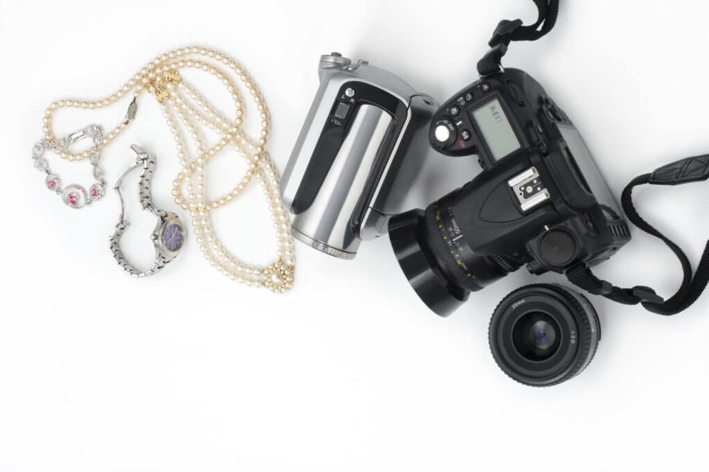 valuable items and jewelry insurance concept with camera and jewelry on a table