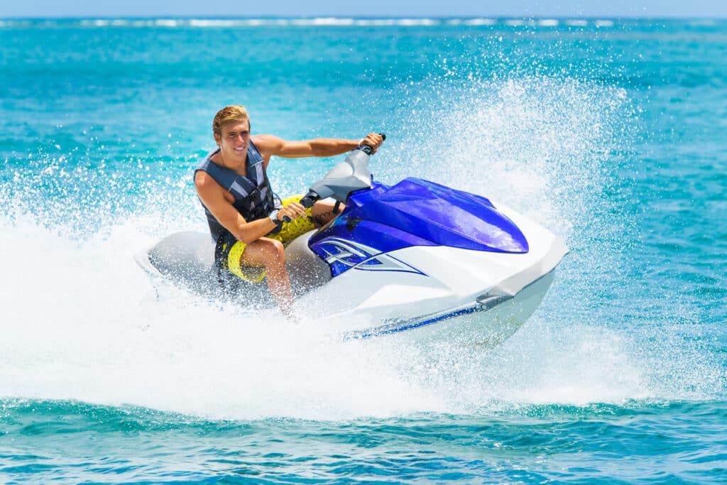 Young Man on Jet Ski, Tropical Ocean, Watercraft Insurance Concept