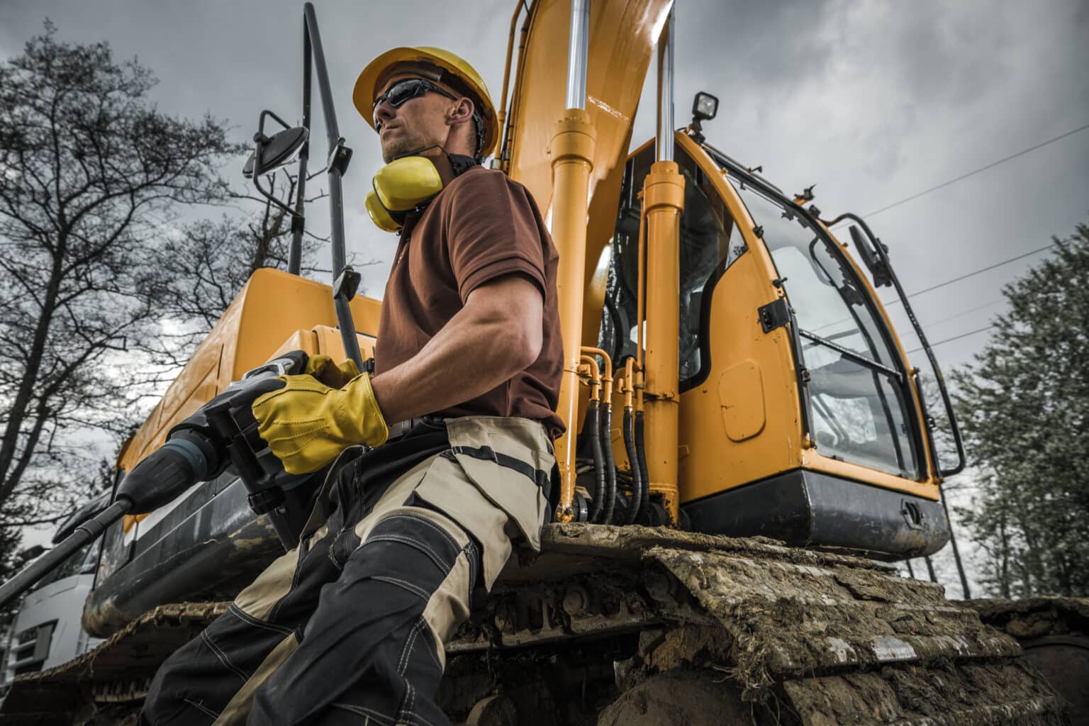 Inland marine contractors insurance concept with man in front of excavator Heavy Duty Machinery Theme.