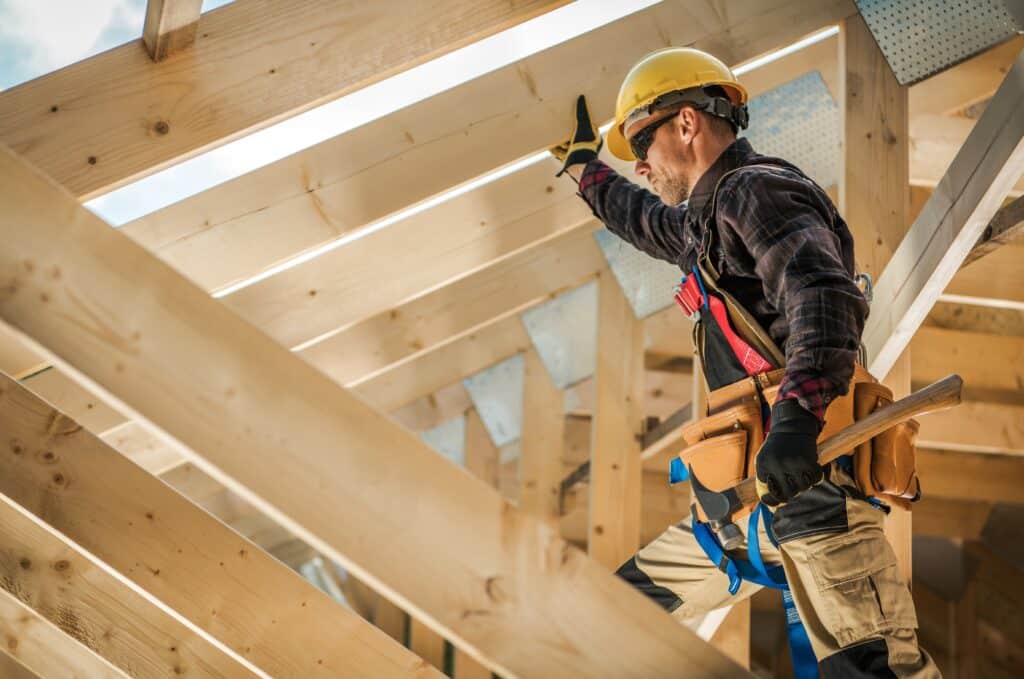 general liability for independent contractors concept with contractor working on house frame