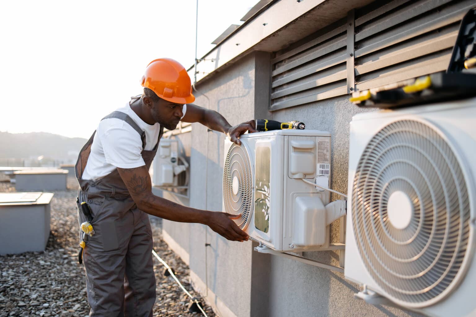 HVAC business concept African american worker installing HVAC outdoors.