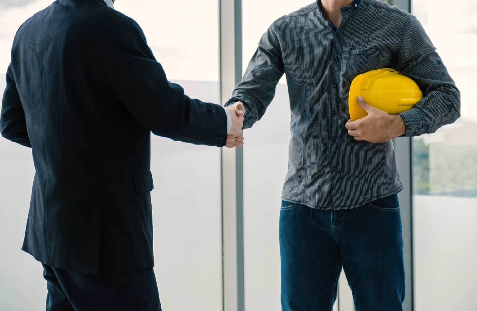Engineer contractor shaking hands with insurance agent after a meeting about insurance bonds