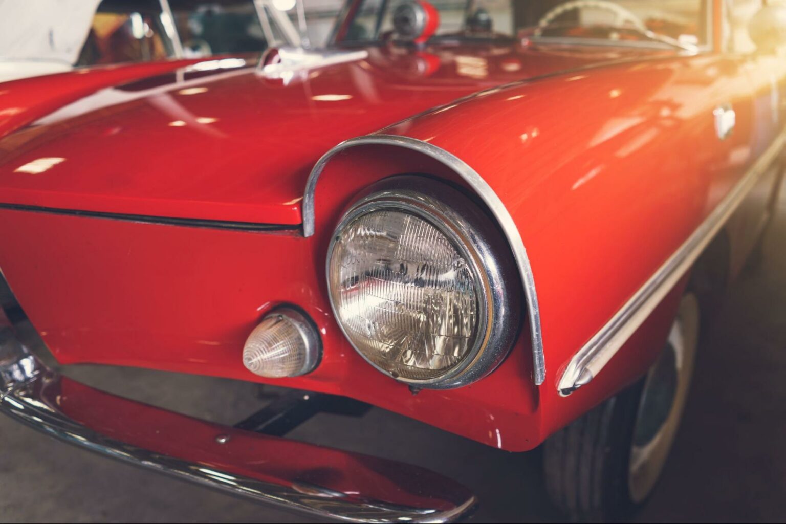 Close-up of a classic red car showcasing its vintage style and charming details.
