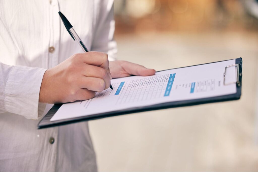 Taking notes on a clipboard for easy reference and organization.