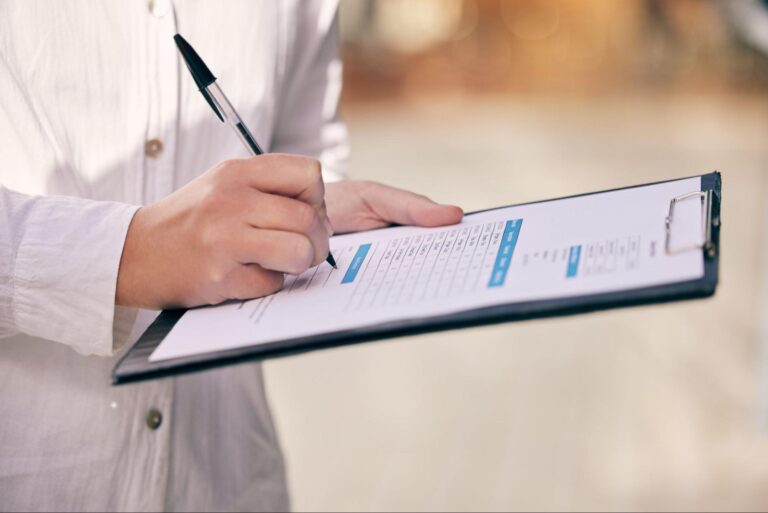 Taking notes on a clipboard for easy reference and organization.