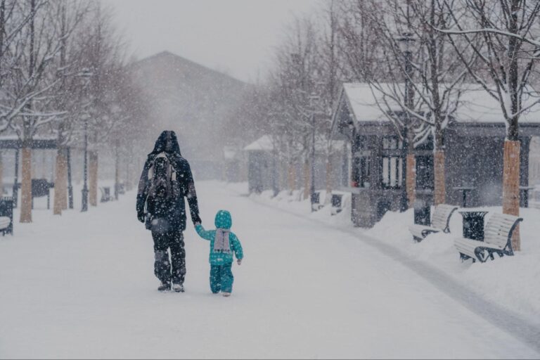 Family enjoying a snowy walk in a winter wonderland.