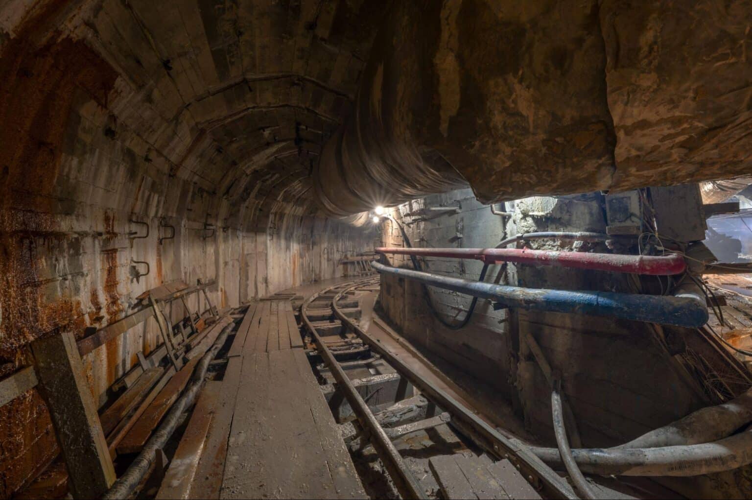 Inside view of a tunnel with wooden tracks and industrial equipment.