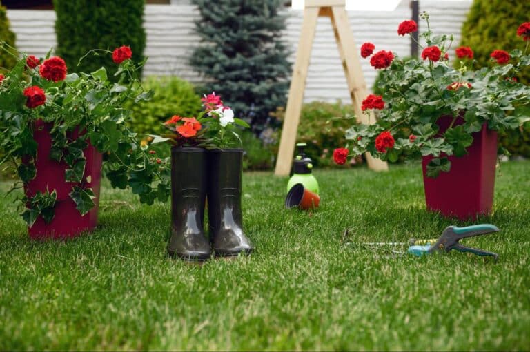 Gardening boots among colorful flowers in a lush garden setting.