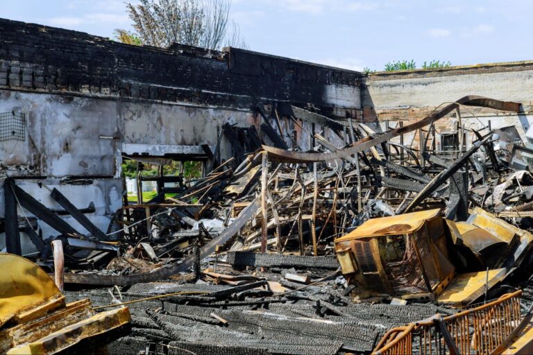 Devastating aftermath of a burned building, showcasing charred remains and debris.