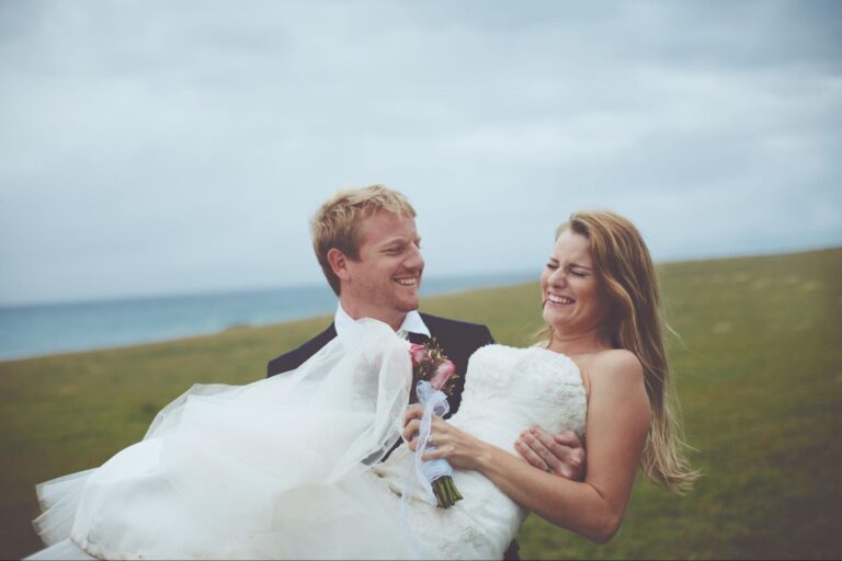 Happy couple enjoying their wedding celebration outdoors by the ocean.
