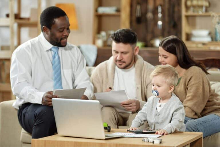 Family discussing important documents with a financial advisor in a cozy living room.