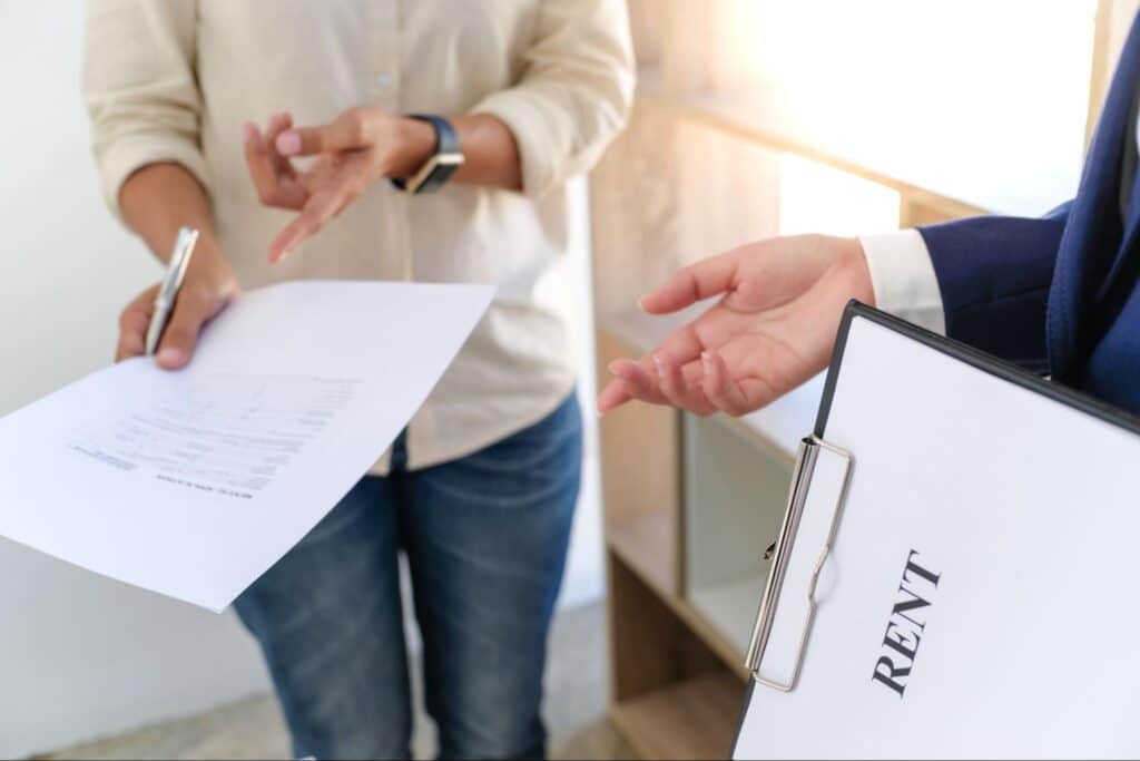 Tenant discussing rental agreement with landlord during property view.