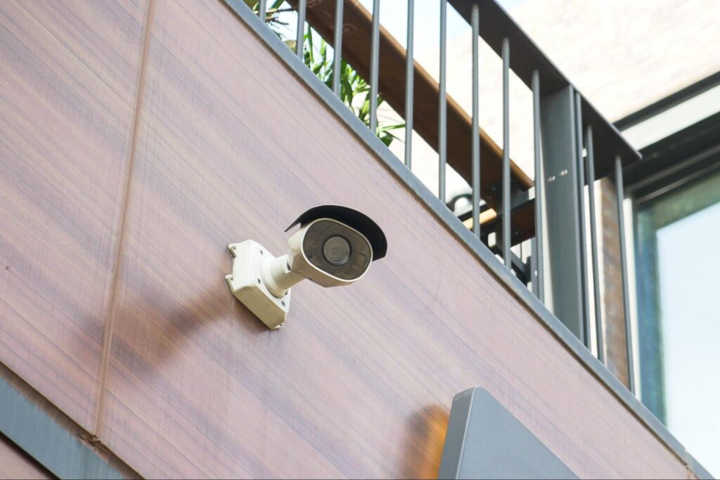 Security camera installed on building exterior for safety and surveillance purposes conveying an insurance fraud prevention tip concept