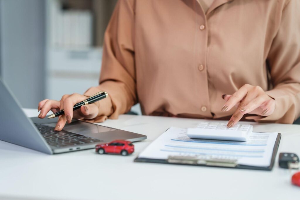 Calculating car expenses with a laptop for busy individuals efficient financial management.