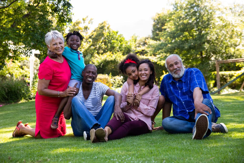 Happy multi-generational family enjoying time together in a garden, smiling and embracing.