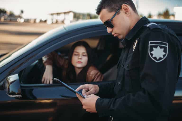 Police officer checks drivers license during a traffic stop for safety and compliance.