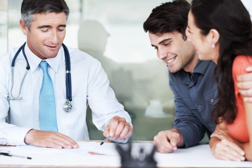 Doctor discussing health options with satisfied patients in a friendly consultation.
