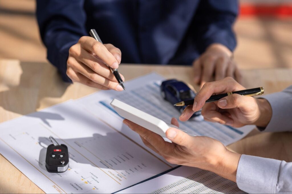 Client and agent signing auto insurance documents together at the office.