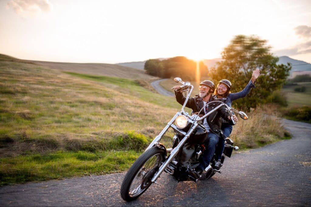 Couple enjoying a scenic motorcycle ride at sunset in beautiful countryside.