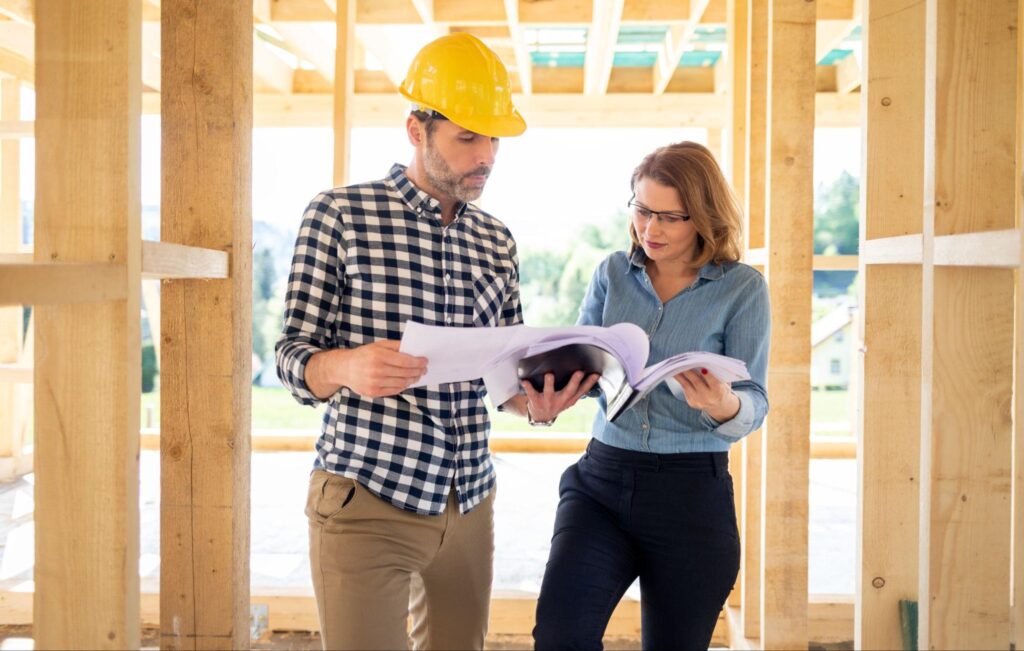 Construction professionals reviewing project plans in a new building framework.